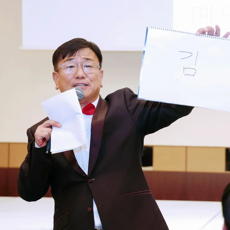 흰 종이를 들고 행사 참석자에게 문제를 내는 신용주 MC