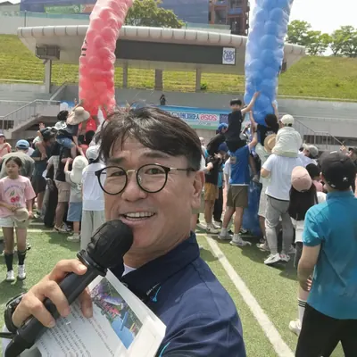 풍선 기둥이 세워진 행사장에서 마이크를 든 신용주 MC