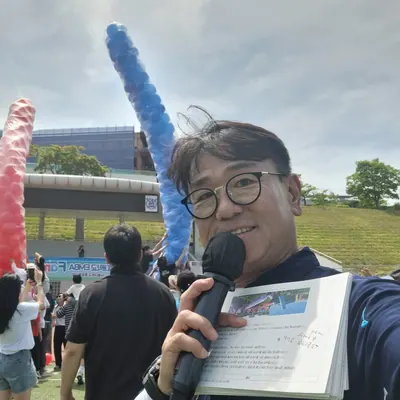 풍선 기둥이 세워진 행사장에서 마이크를 든 신용주 MC