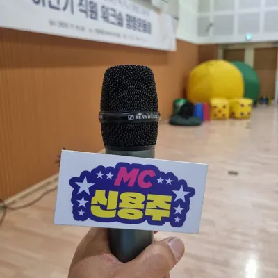 MC 신용주 명패가 달린 마이크를 든 손