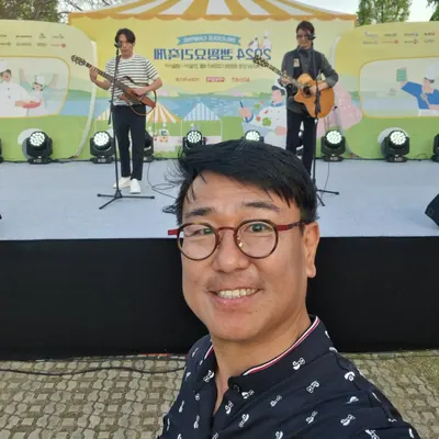 야외 축제 무대 앞에서 셀카를 찍은 신용주 MC