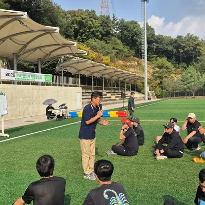 야외 운동장에 모여 앉은 단체 참가자들과 진행 현장 전경