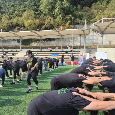 넓은 잔디 구장에서 진행 중인 단체 레크리에이션 프로그램