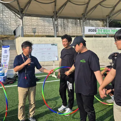 잔디 운동장에서 참가자들이 팀 활동과 게임에 참여하는 워크숍 현장