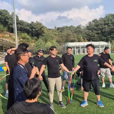 넓은 잔디 구장에서 진행 중인 단체 레크리에이션 프로그램