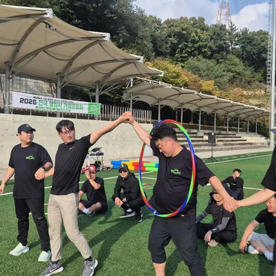 넓은 잔디 구장에서 진행 중인 단체 레크리에이션 프로그램