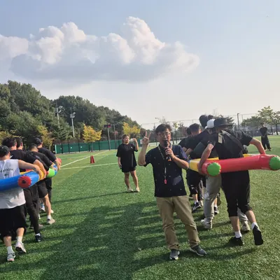 넓은 잔디 구장에서 진행 중인 단체 레크리에이션 프로그램