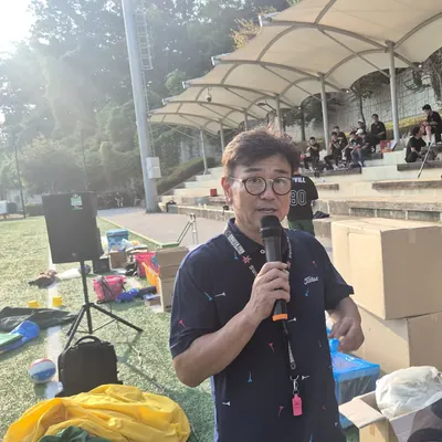 마이크를 쥐고 야외 프로그램을 진행하는 사회자