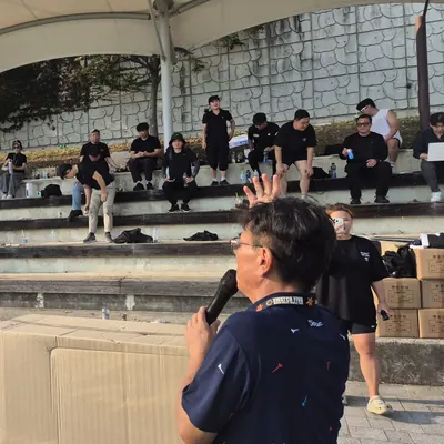 운동장에서 게임 방법을 안내하는 진행자와 참가자들